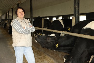 Photo of Portrait of farmer with cute cows inside cowshed in dairy farm