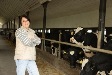 Photo of Portrait of farmer with cute cows inside cowshed in dairy farm