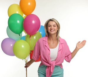 Photo of Smiling woman with bunch of colorful balloons on white background