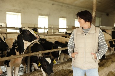 Photo of Farmer with cute cows inside cowshed in dairy farm
