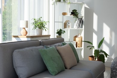 Photo of Stylish sofa and other furniture in living room, closeup. Interior design