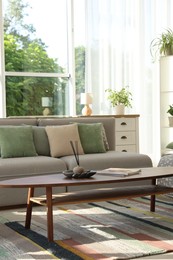 Photo of Stylish sofa and other furniture in living room. Interior design