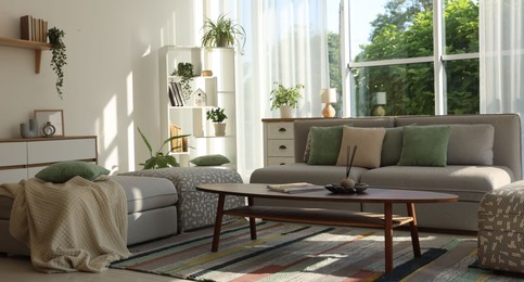 Photo of Stylish sofa and other furniture in living room. Interior design