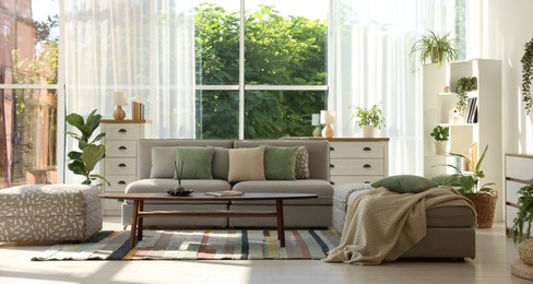 Photo of Stylish sofa and other furniture in living room. Interior design