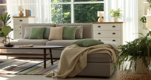 Photo of Stylish sofa and other furniture in living room. Interior design