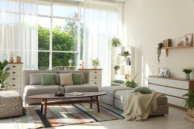 Photo of Stylish sofa and other furniture in living room. Interior design