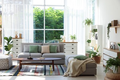 Photo of Stylish sofa and other furniture in living room. Interior design