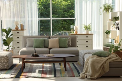 Photo of Stylish sofa and other furniture in living room. Interior design