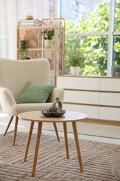 Photo of Comfortable armchair and other furniture in living room. Interior design