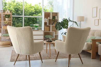Photo of Comfortable armchairs and other furniture in living room. Interior design