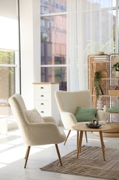 Photo of Comfortable armchairs and other furniture in living room. Interior design