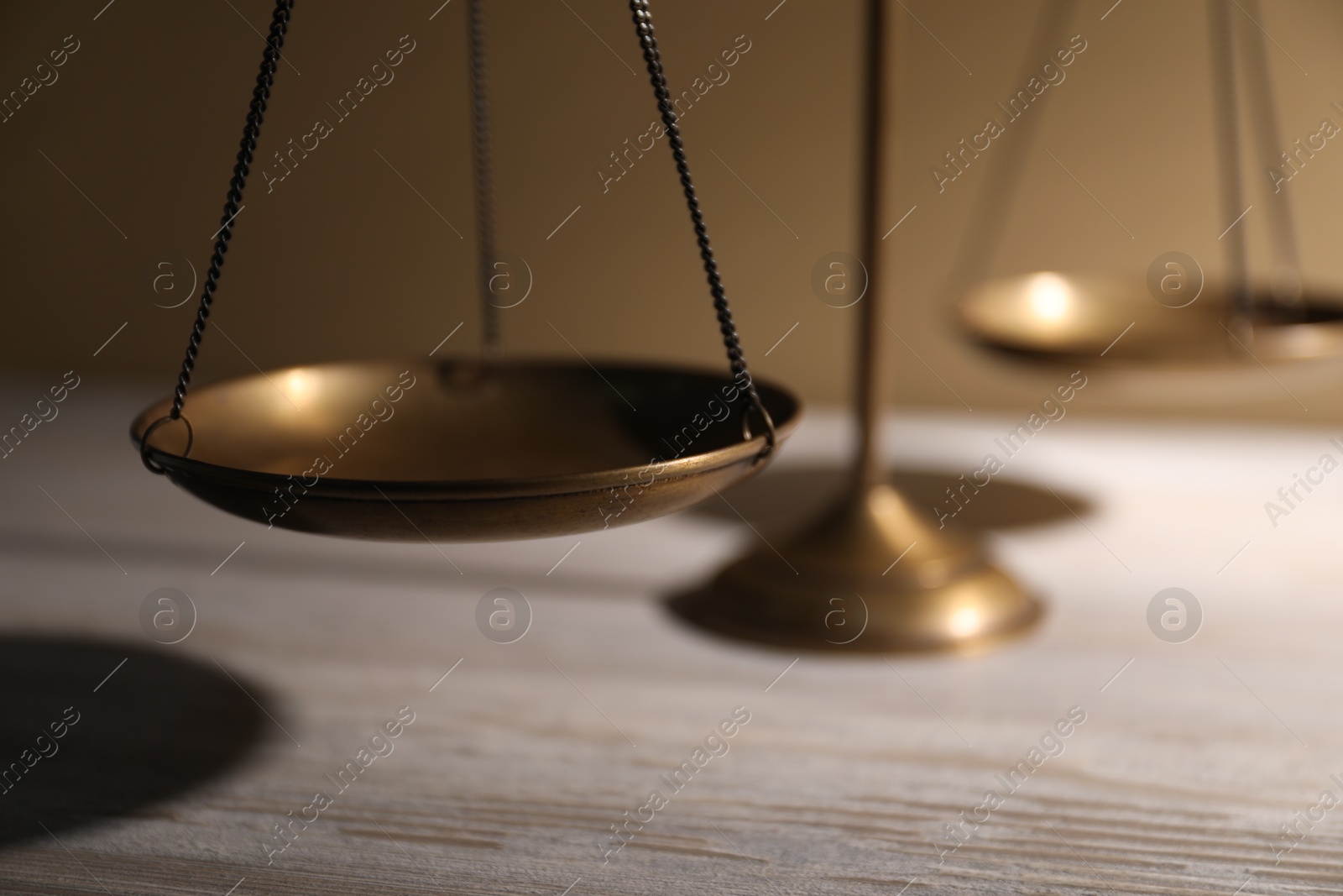 Scales of justice on wooden table against beige background, closeup Photo of Scales of justice on wooden table against beige background, closeup