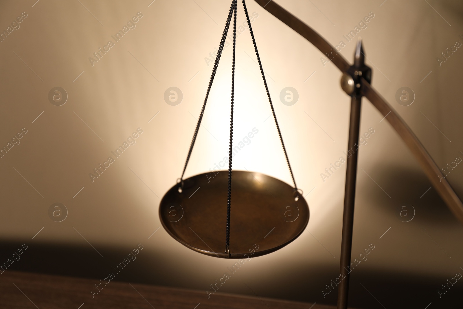 Photo of Scales of justice on beige background, closeup