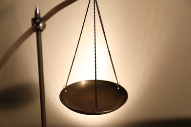 Photo of Scales of justice on beige background, closeup