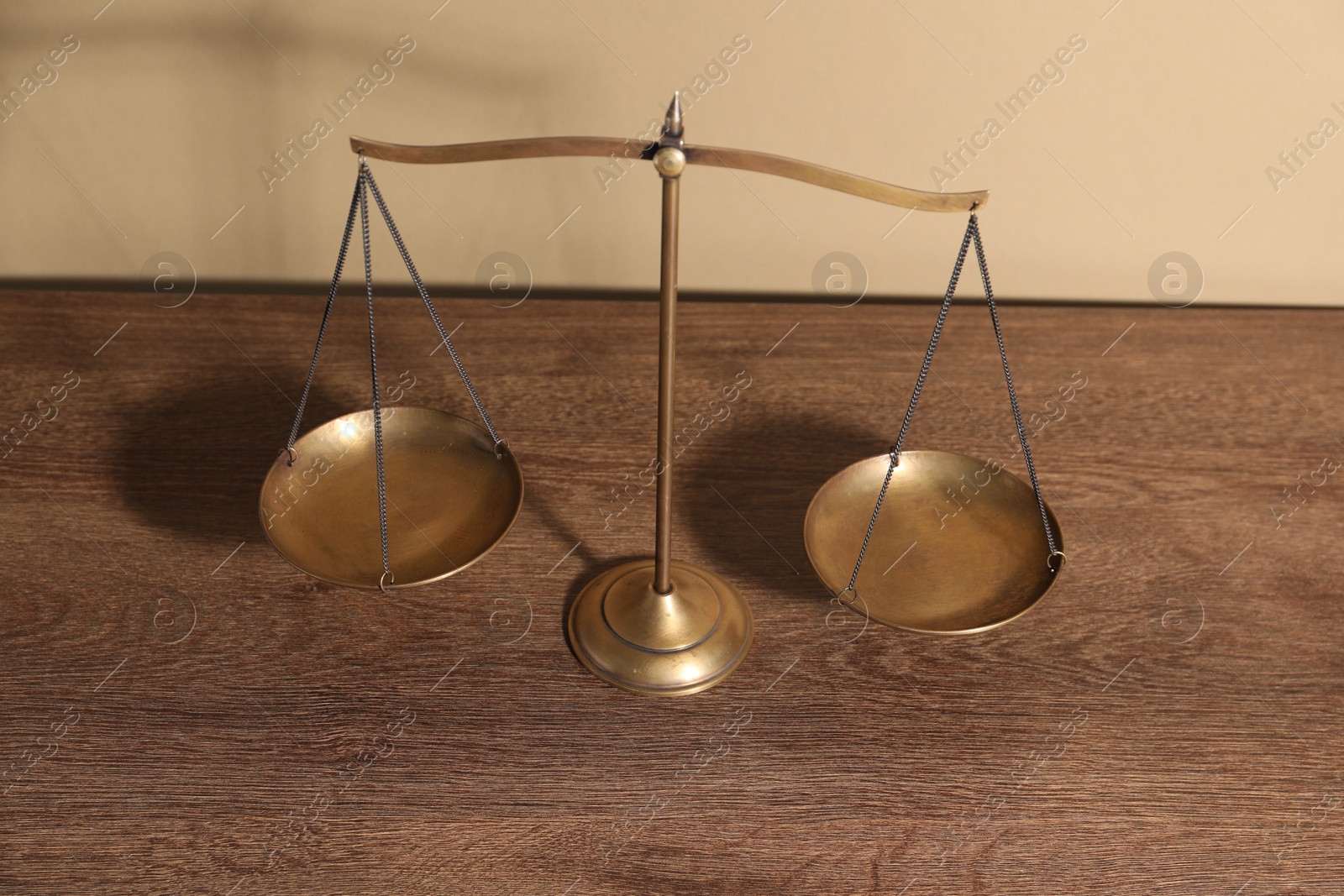 Photo of Scales of justice on wooden table, above view
