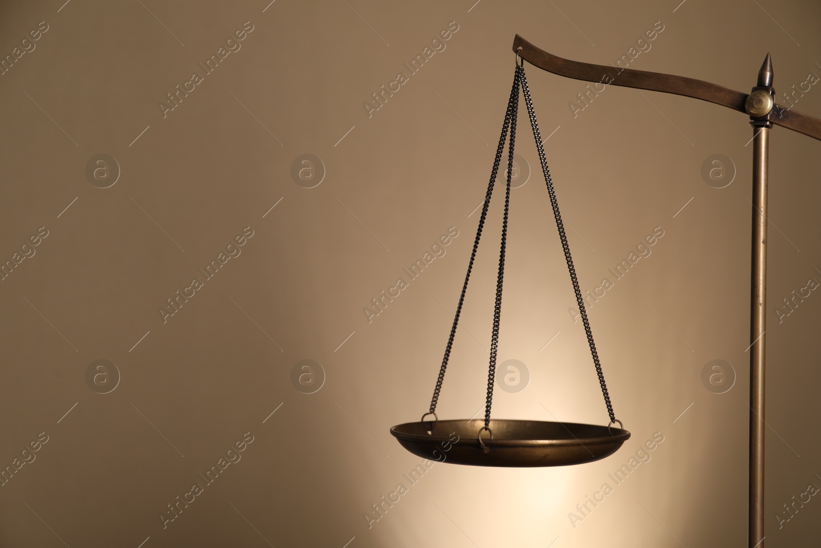 Photo of Scales of justice on beige background, closeup. Space for text