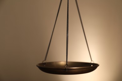 Photo of Scales of justice on beige background, closeup