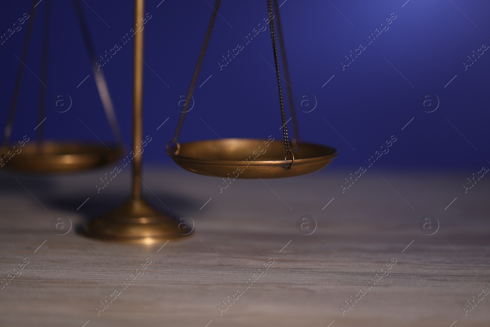 Scales of justice on wooden table against dark background, closeup Photo of Scales of justice on wooden table against dark background, closeup