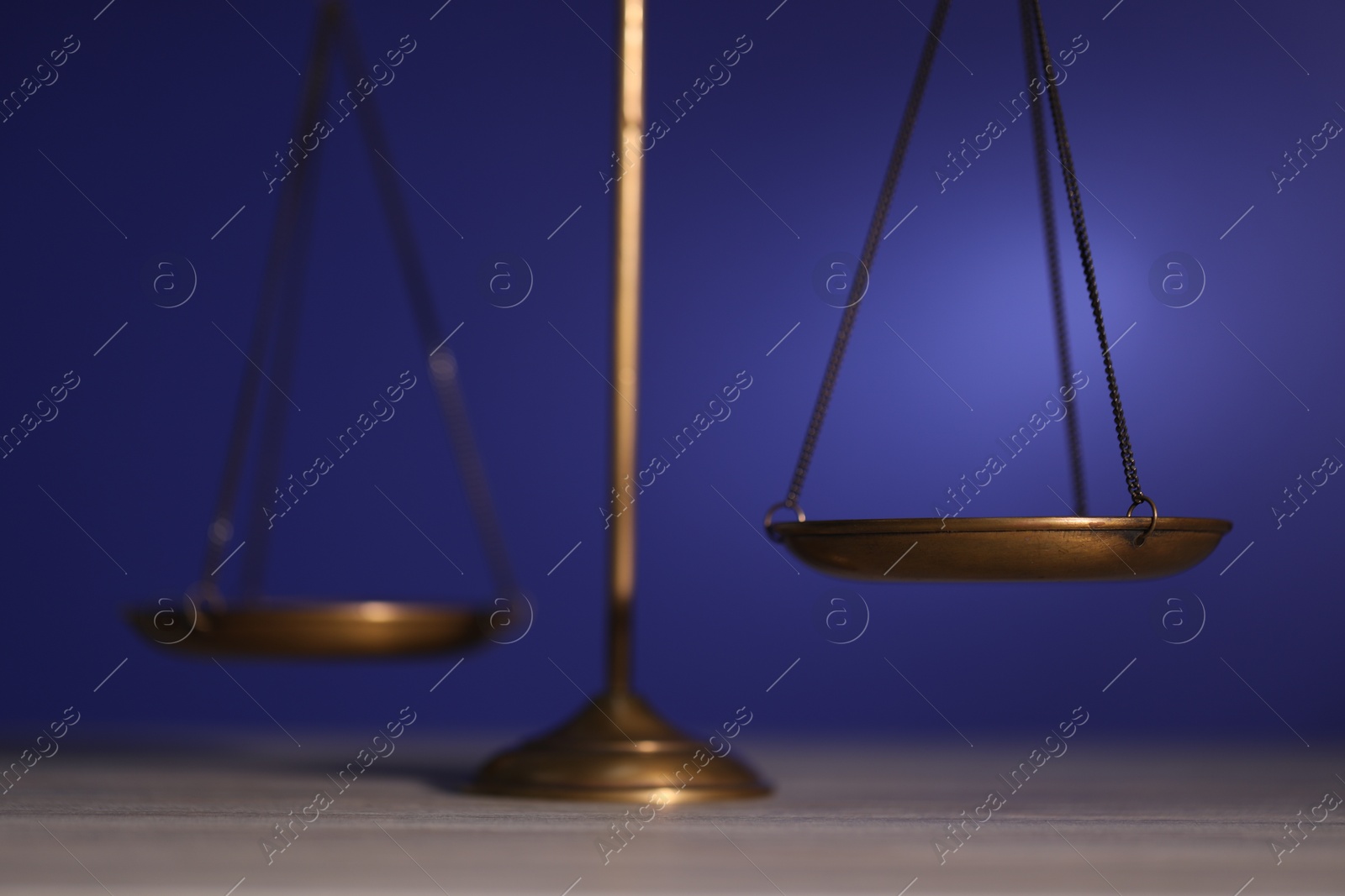Scales of justice on wooden table against dark background, closeup Photo of Scales of justice on wooden table against dark background, closeup