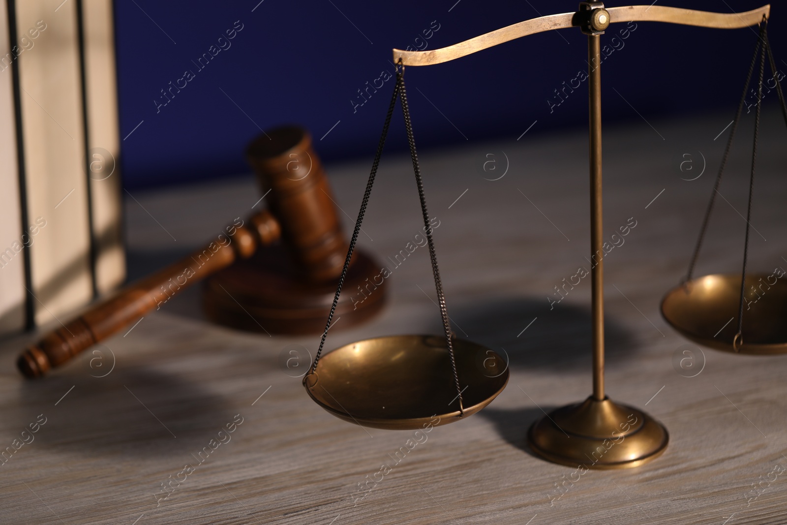 Photo of Scales of justice, books and judge's gavel on wooden table, closeup