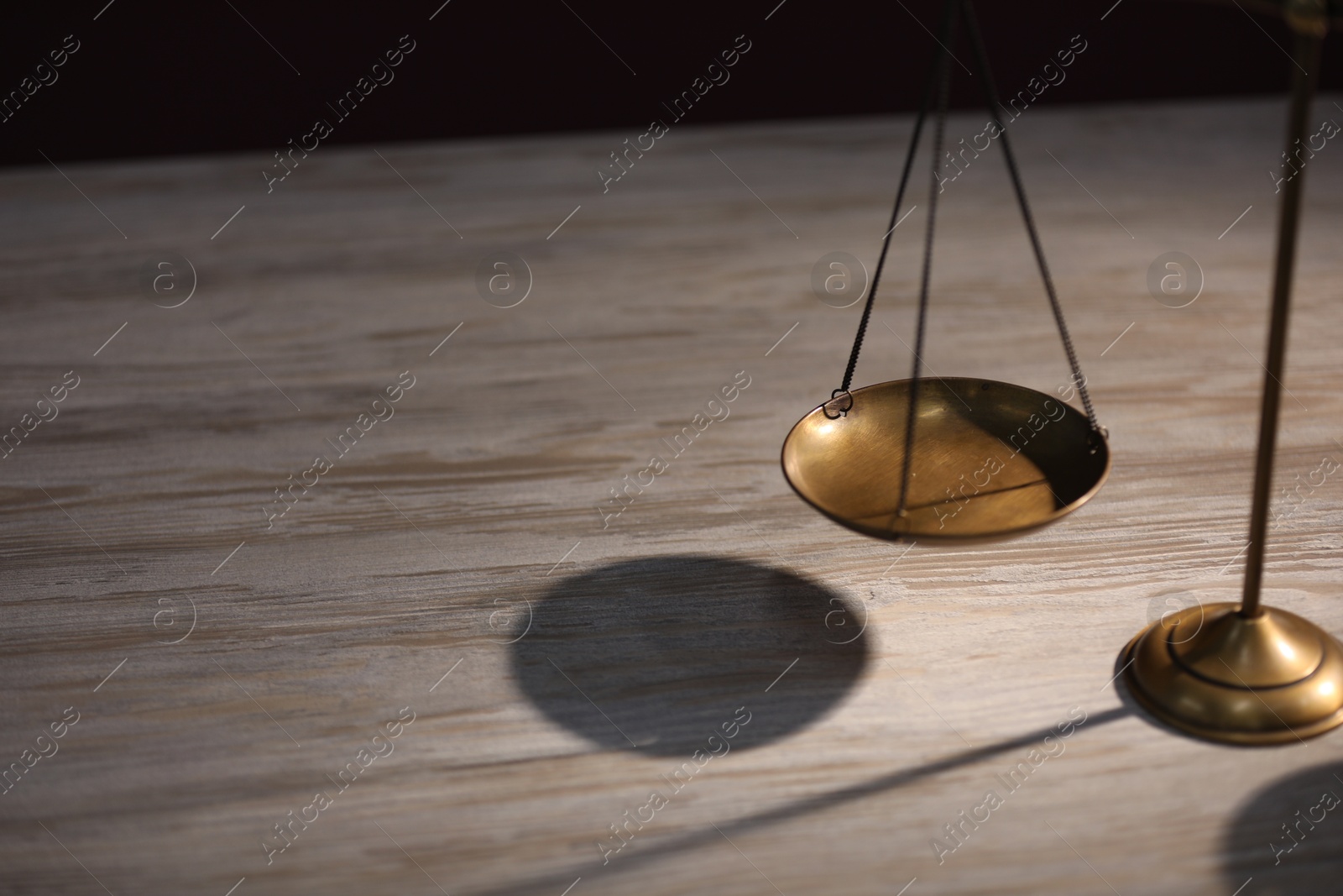 Photo of Scales of justice on wooden table, closeup. Space for text