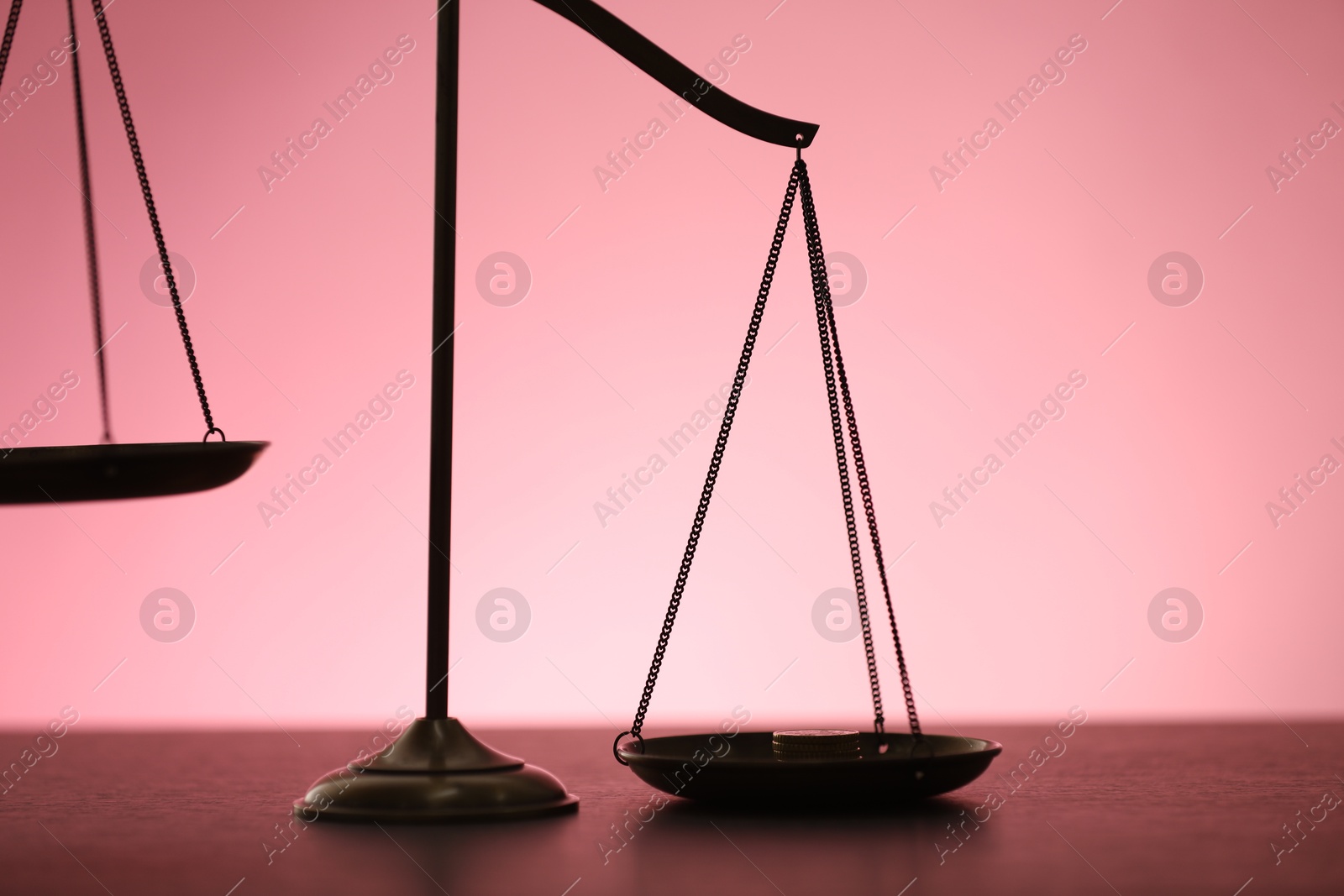 Scales of justice on table against color background, closeup Photo of Scales of justice on table against color background, closeup