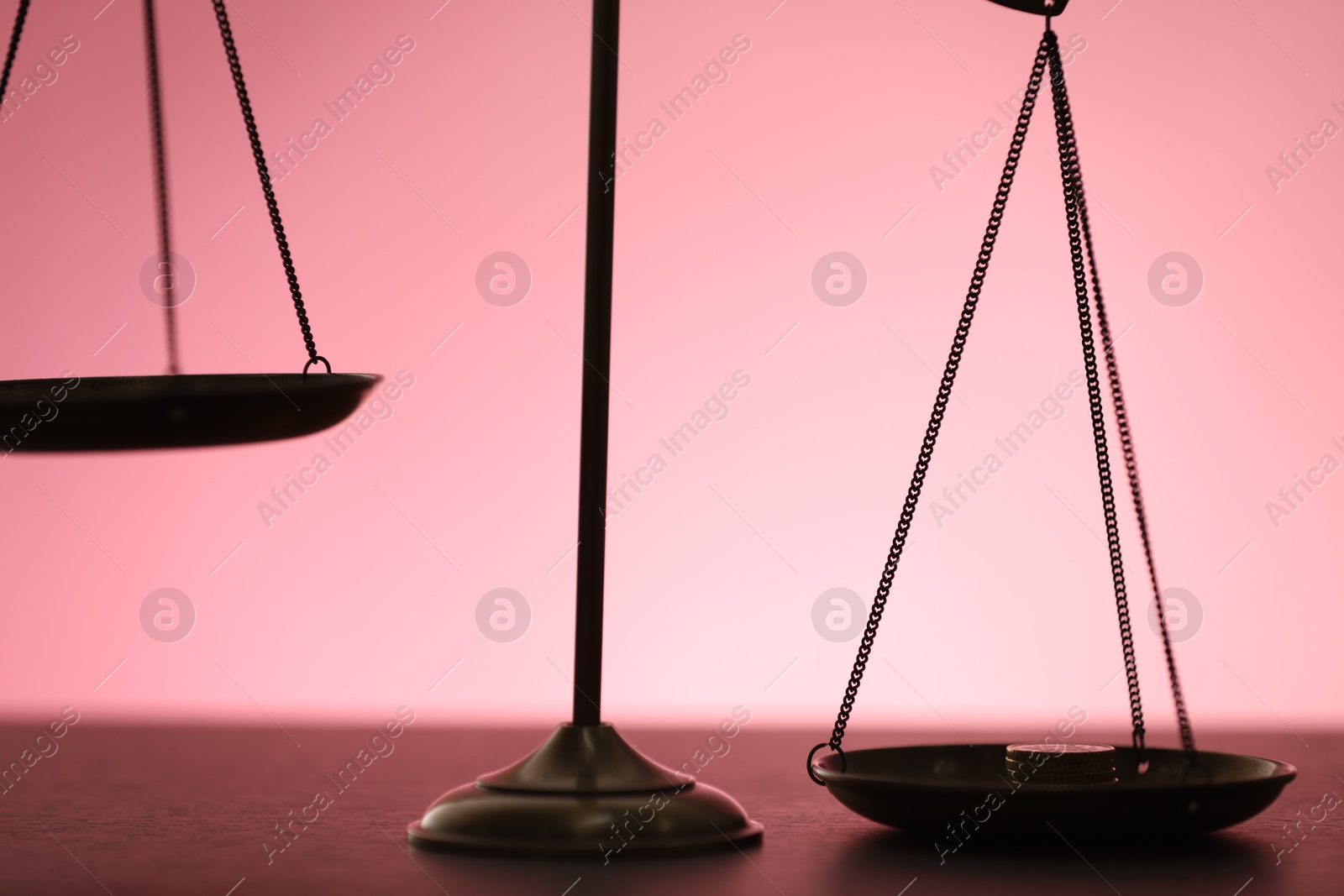 Scales of justice on table against color background, closeup Photo of Scales of justice on table against color background, closeup