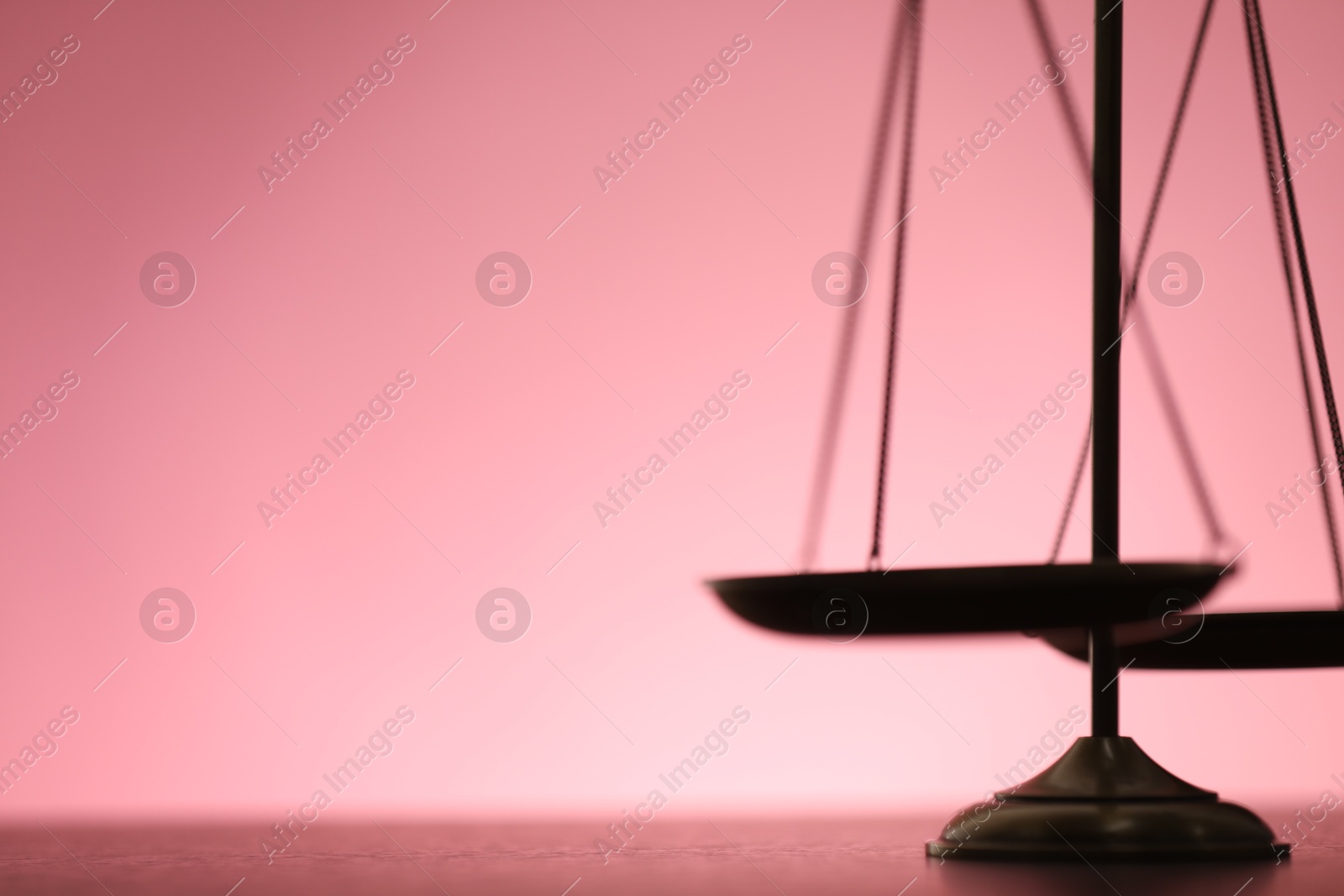 Scales of justice on table against color background, closeup. Space for text Photo of Scales of justice on table against color background, closeup. Space for text