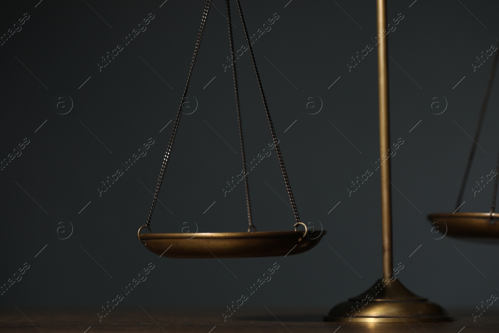 Scales of justice on table against gray background, closeup Photo of Scales of justice on table against gray background, closeup