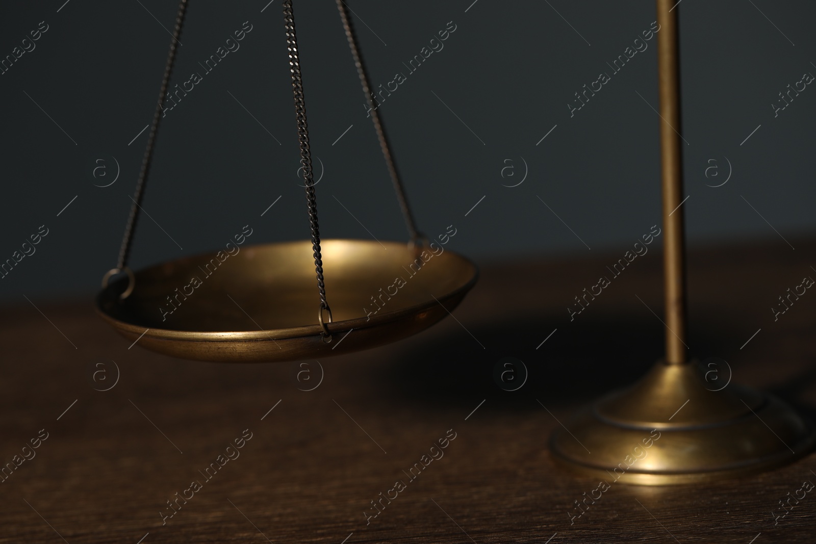 Scales of justice on wooden table against gray background, closeup Photo of Scales of justice on wooden table against gray background, closeup