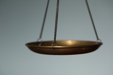 Photo of Scales of justice on light background, closeup
