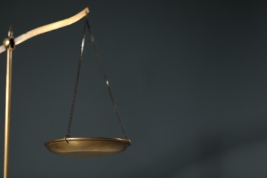 Photo of Scales of justice on gray background, closeup. Space for text