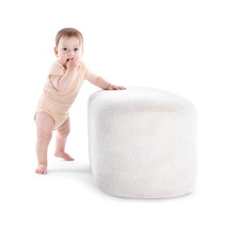Photo of First steps. Cute little baby in diaper near pouf on white background