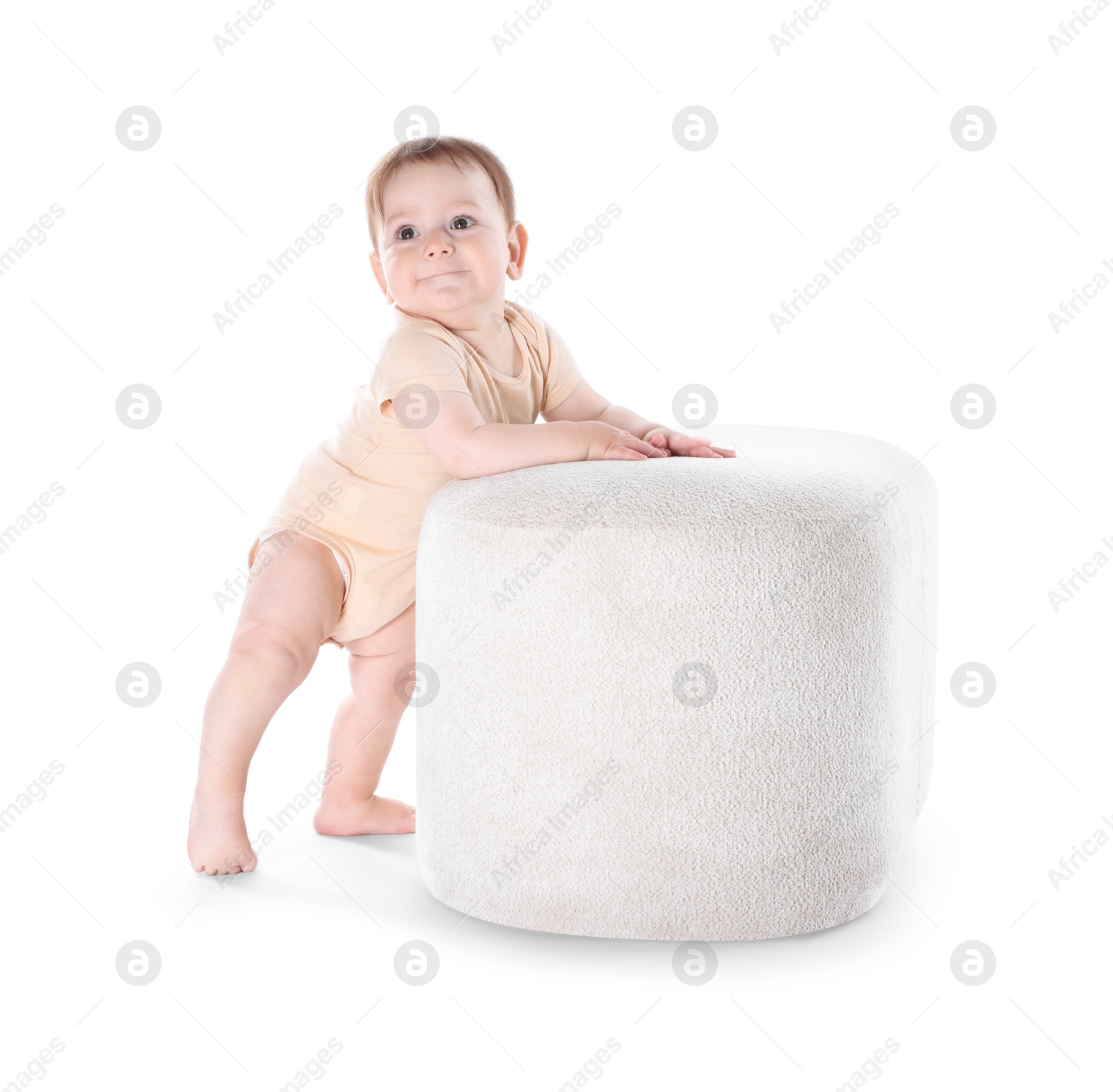 First steps. Cute little baby in diaper near pouf on white background Photo of First steps. Cute little baby in diaper near pouf on white background