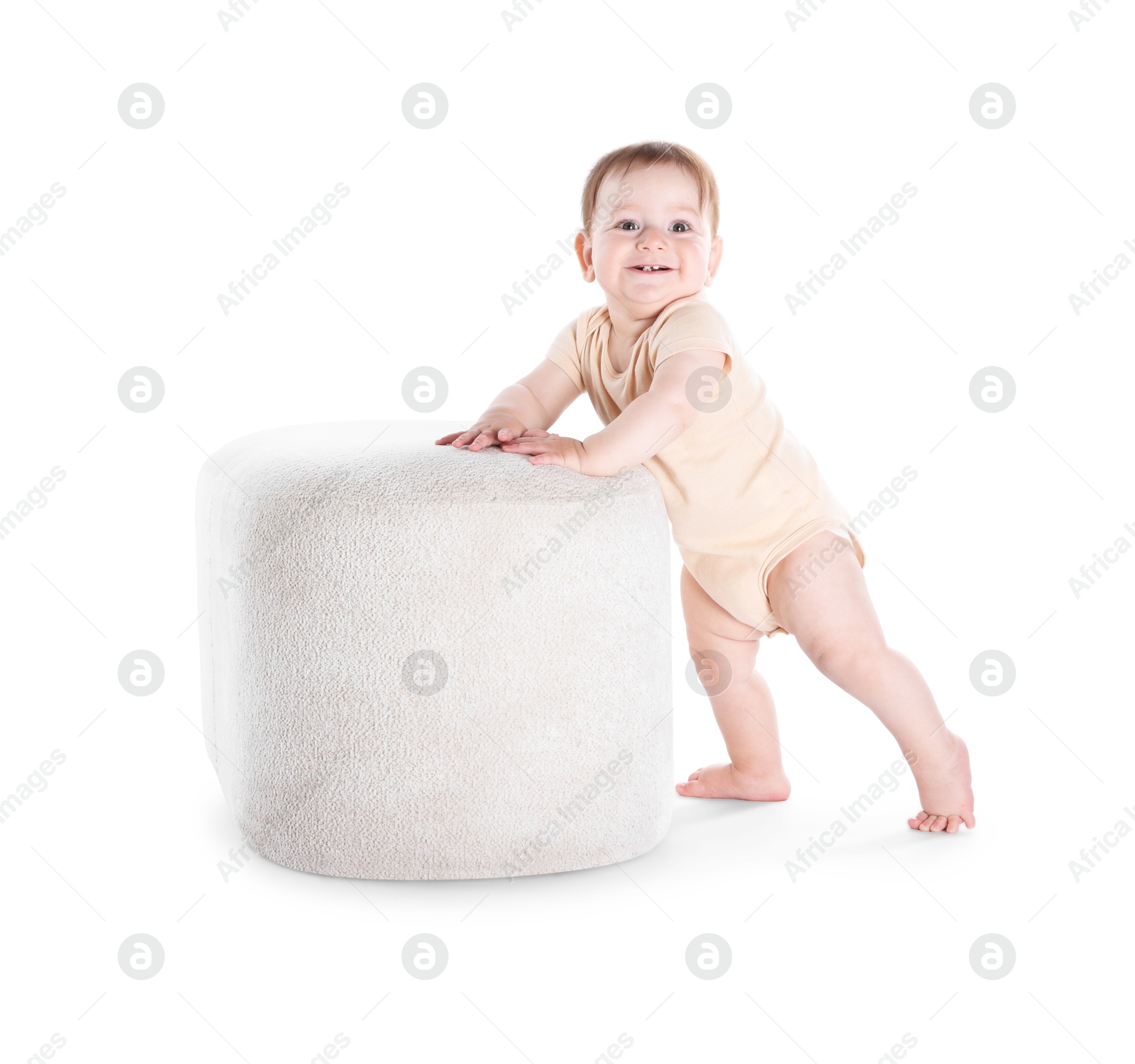 First steps. Cute little baby in diaper near pouf on white background Photo of First steps. Cute little baby in diaper near pouf on white background