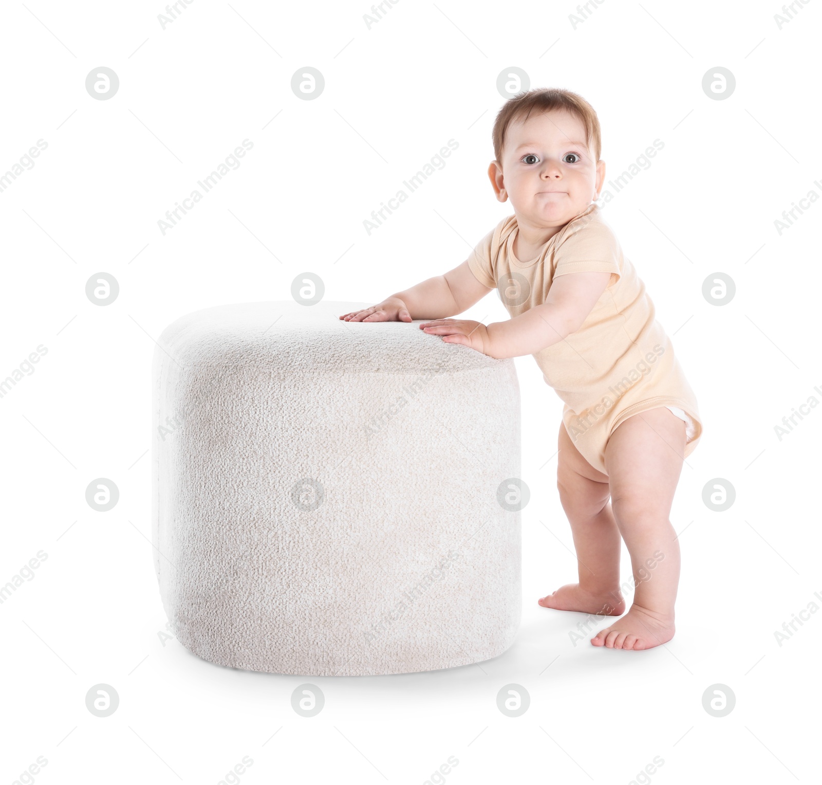 First steps. Cute little baby in diaper near pouf on white background Photo of First steps. Cute little baby in diaper near pouf on white background