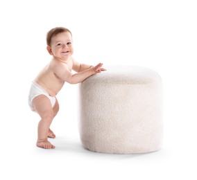 Photo of First steps. Cute little baby in diaper near pouf on white background