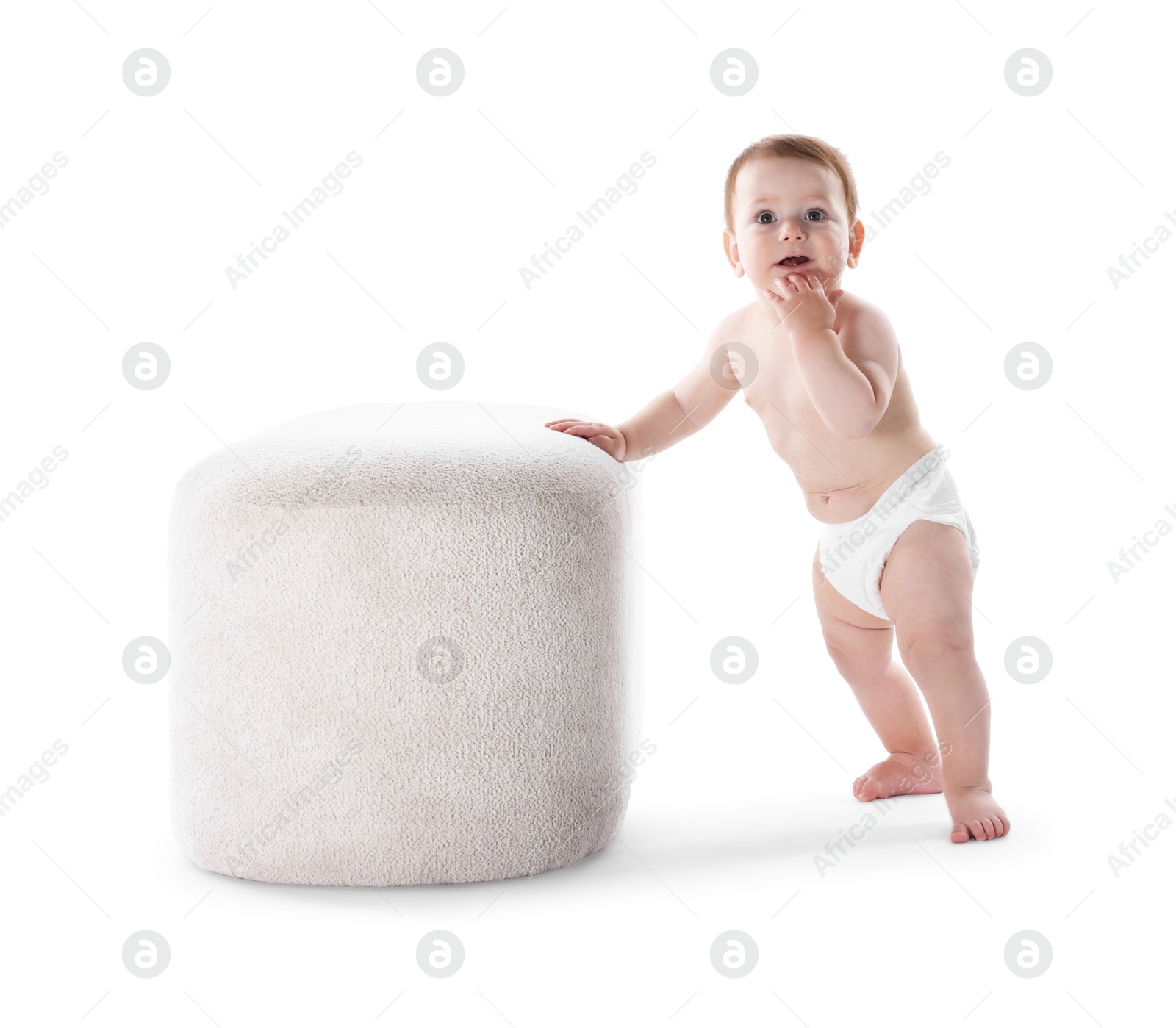 First steps. Cute little baby in diaper near pouf on white background Photo of First steps. Cute little baby in diaper near pouf on white background
