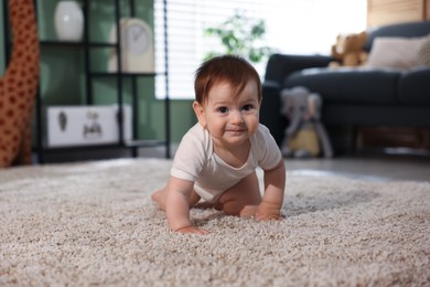 Photo of Cute little baby crawling on carpet at home