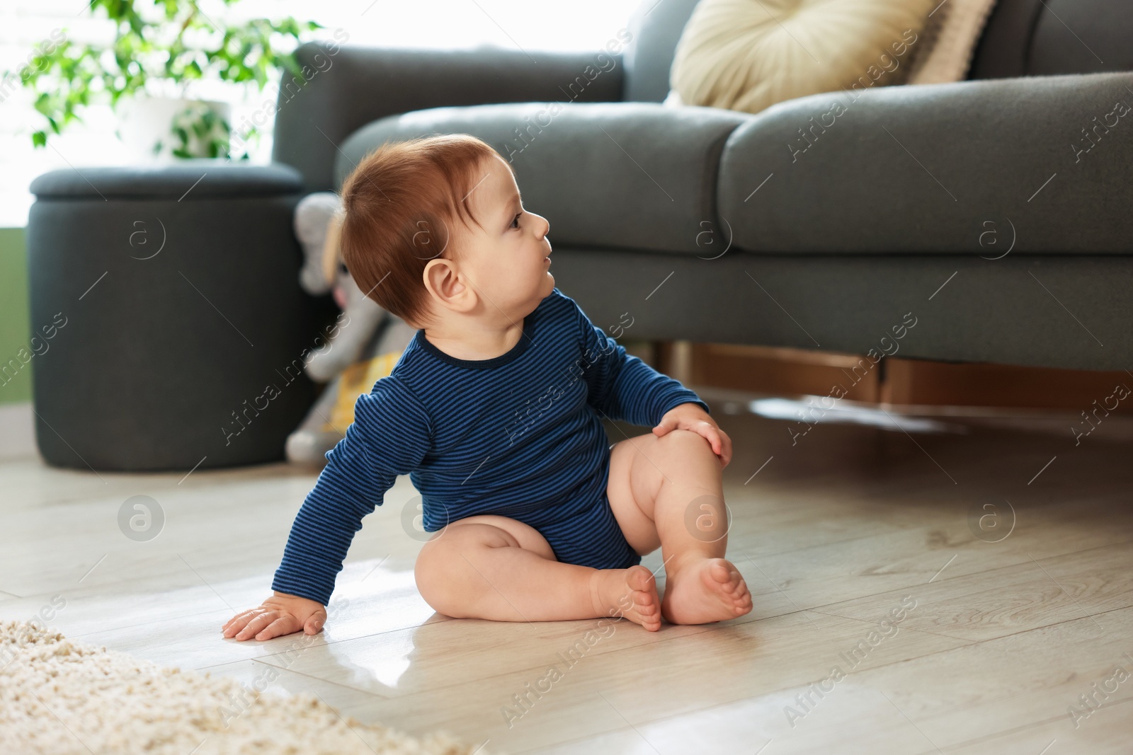 Cute little baby sitting on floor at home Photo of Cute little baby sitting on floor at home