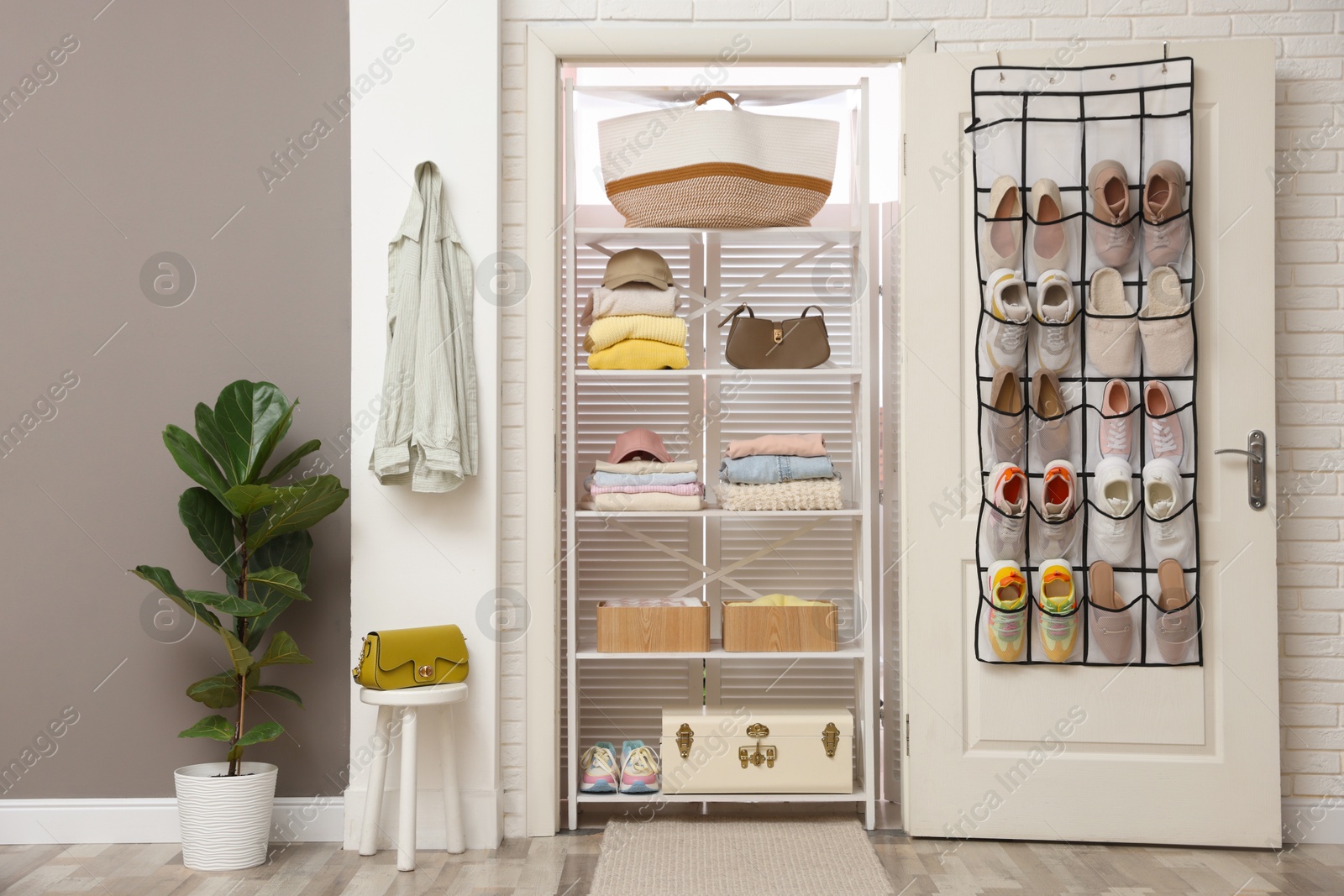 Organizer with different footwear on door, accessories and clothes indoors. Shoe storage Photo of Organizer with different footwear on door, accessories and clothes indoors. Shoe storage