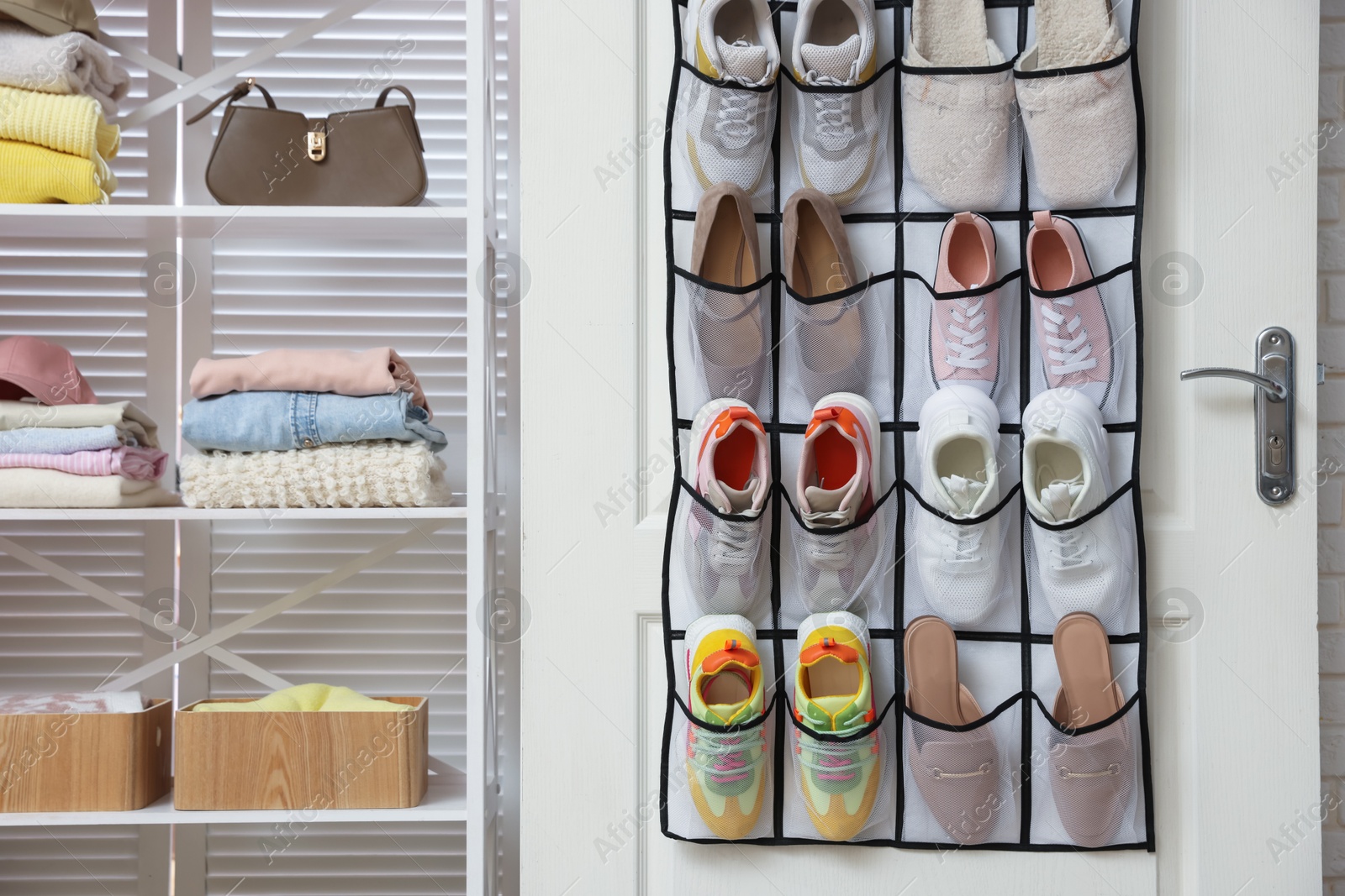 Organizer with different footwear on door, accessories and clothes indoors. Shoe storage Photo of Organizer with different footwear on door, accessories and clothes indoors. Shoe storage