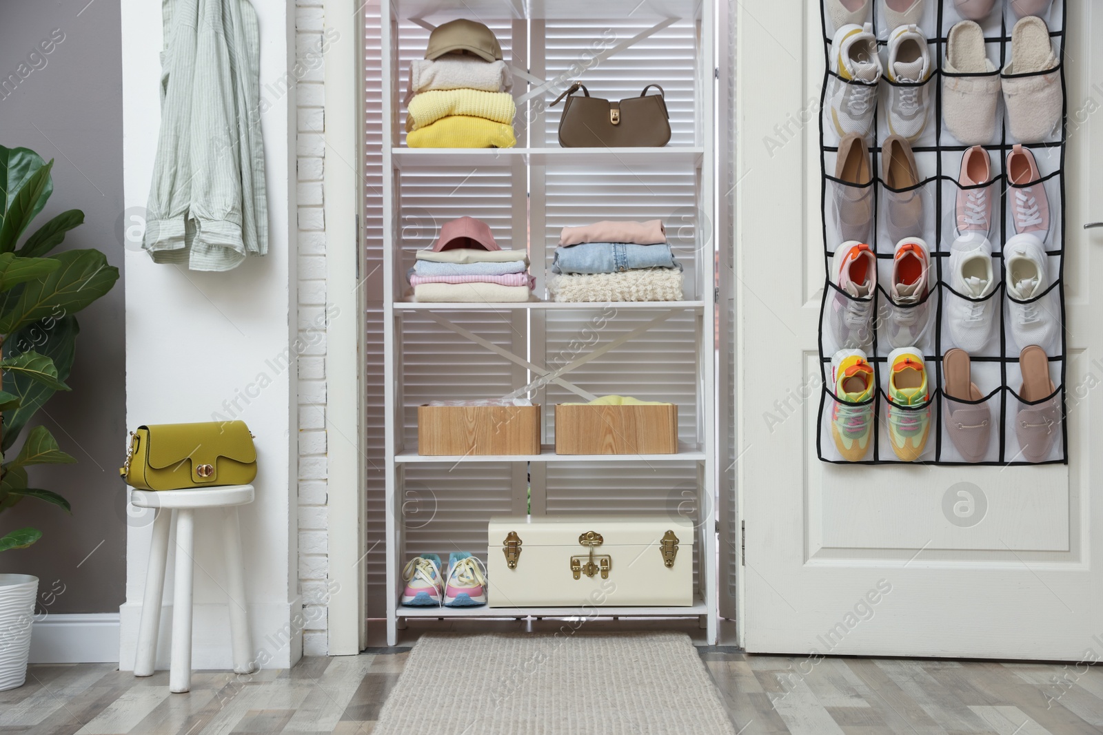Organizer with different footwear on door, accessories and clothes indoors. Shoe storage Photo of Organizer with different footwear on door, accessories and clothes indoors. Shoe storage