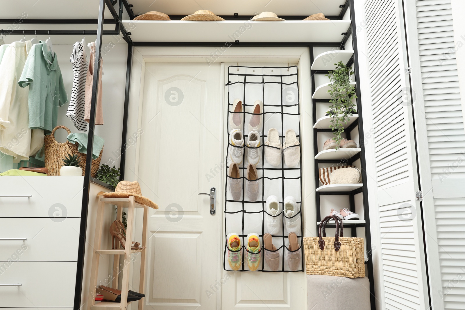 Organizer with different footwear, accessories and clothes indoors, low angle view. Shoe storage Photo of Organizer with different footwear, accessories and clothes indoors, low angle view. Shoe storage