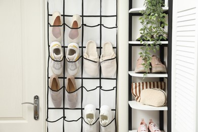 Photo of Organizer with different footwear and accessories indoors. Shoe storage