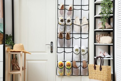 Photo of Organizer with different footwear and accessories indoors. Shoe storage