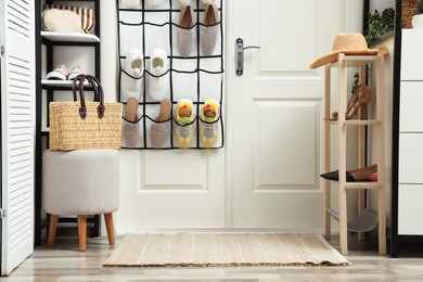 Photo of Organizer with different footwear and accessories indoors. Shoe storage