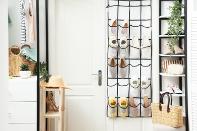 Photo of Organizer with different footwear and accessories indoors. Shoe storage
