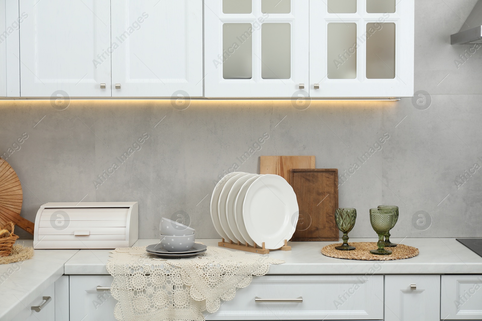 Photo of Clean dishware and glasses on countertop in kitchen