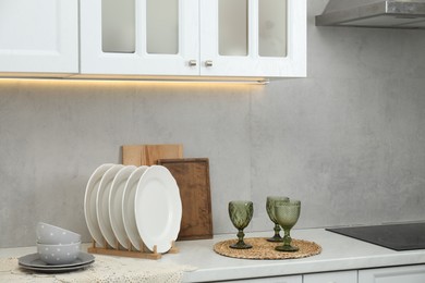 Photo of Clean dishware and glasses on countertop in kitchen